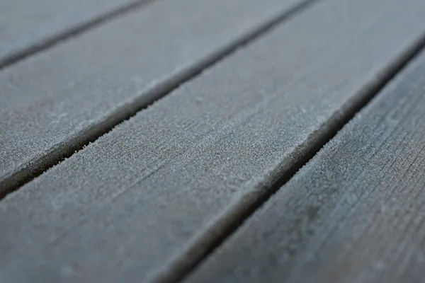 Close-up of grey composite deck boards with embossed grain